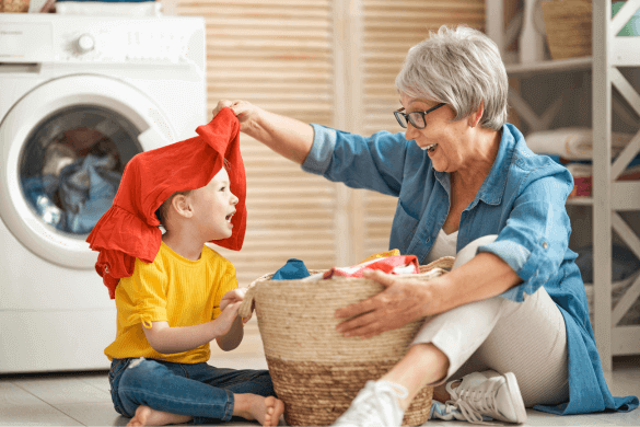Grandmother and child playing and laughing while doing laundry