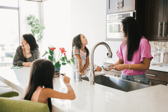 mother doing dishes in the kitchen with children and grandmother