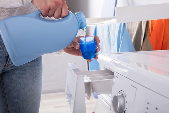 Pouring detergent into washing machine 